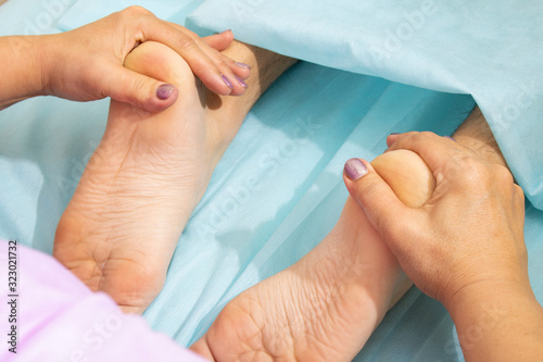 Close-up of female hands doing foot massage. relaxing therapy for feet
