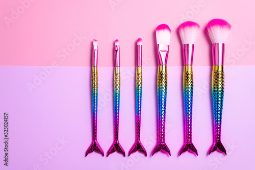 Set of makeup brushes on pink background. Cosmetics accessories for makeup. Minimal composition. Fashion, beauty, makeup concept. Top view, flat lay