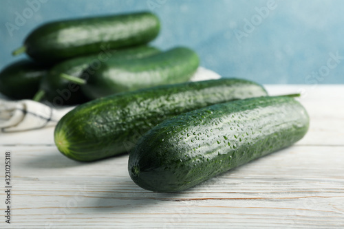 Cucumbers and towel on wooden background, close up