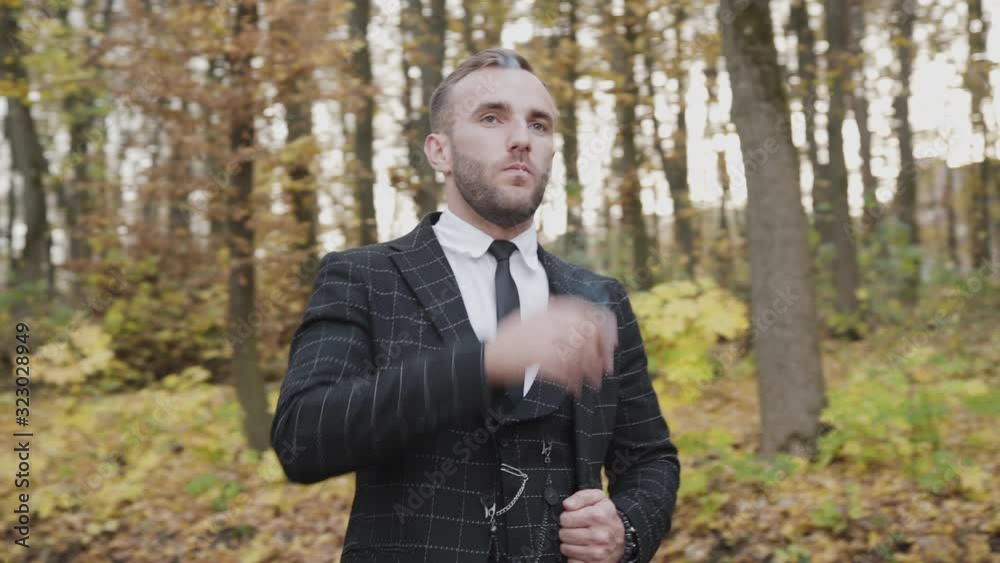 Portrait of handsome gentleman smoking a cigar in autumn forest Portrait of handsome gentleman smoking a cigar in autumn forest