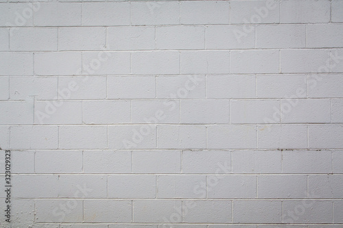White painted cement concrete block wall with varying shades of white, off white and gray photo