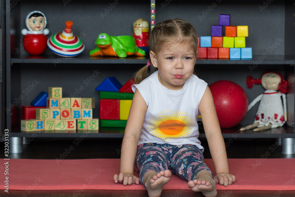 Fotografie Sad and going to cry little girl sitting on ground
