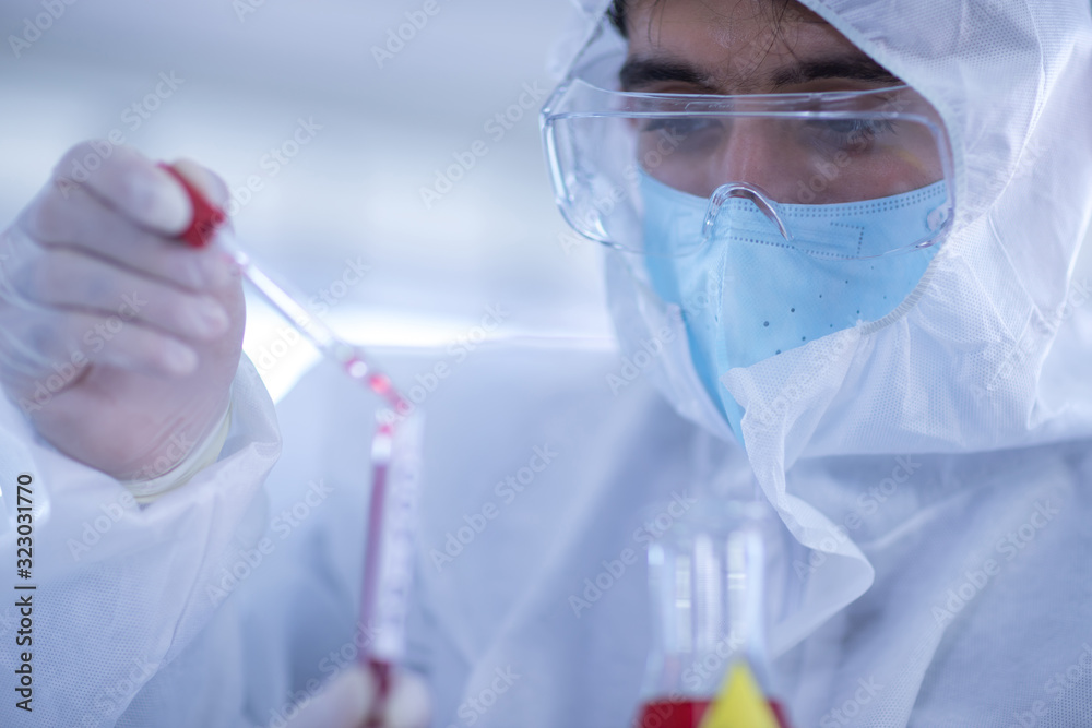 Fototapeta premium Male scientists is experimenting with chemicals in the laboratory. Concept, The scientists wear white protective clothing is experimenting with drug anti- Coronavirus