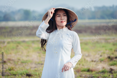 Portrait of Vietnamese girl in national costume with hat.