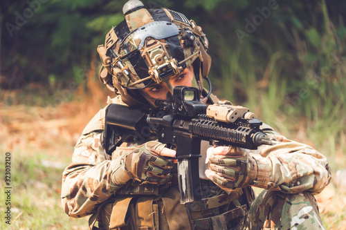 special forces soldier assault rifle with silencer.  Sniper in the forest. photo