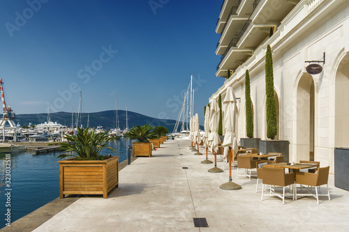 Beautiful and cozy street cafe on the background of luxury yachts at the port of Tivat  Montenegro.