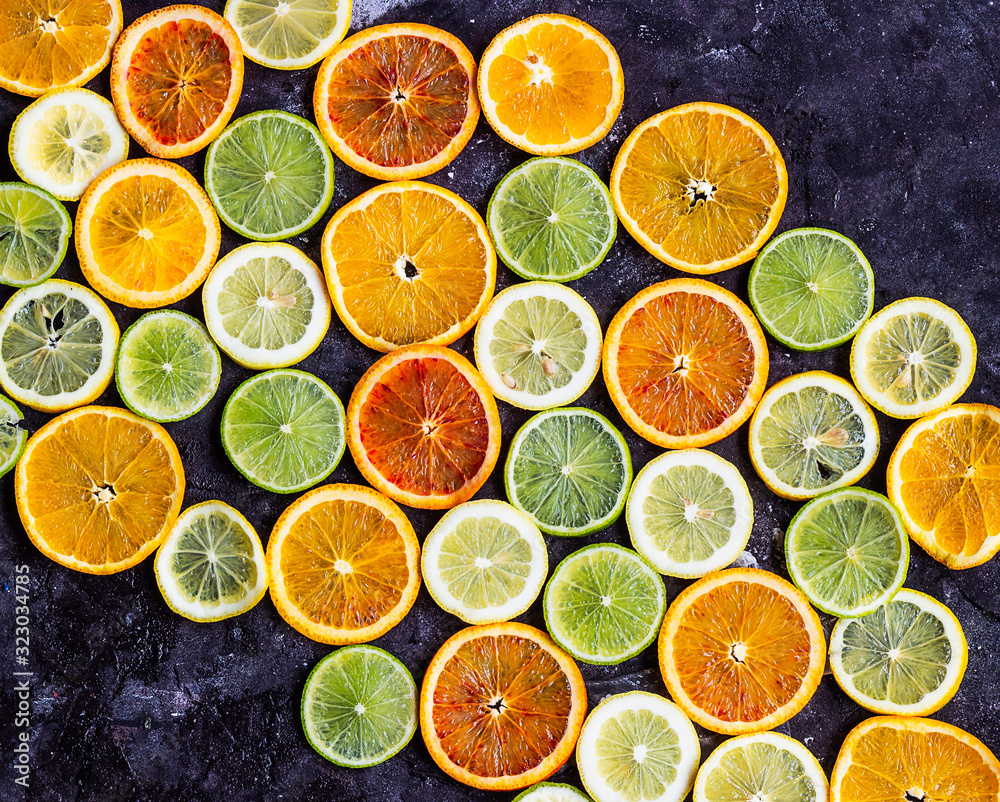 Citrus fruit sliced on dark background creating a pattern Citrus fruit sliced on dark background creating a pattern