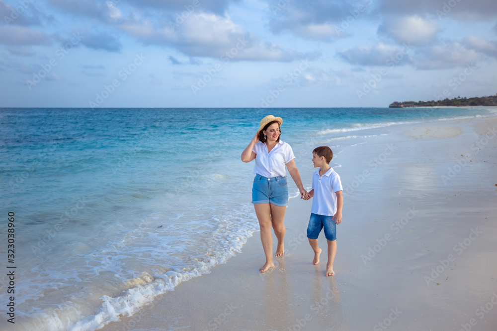 Happy family on vacation: mother and son are walking aSeychelles. Zanzibar islandlong the ocean.