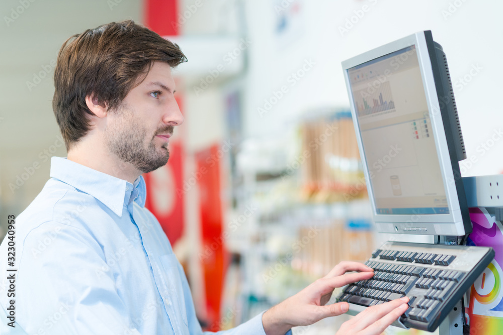man with computer checking stock in computer man with computer checking stock in computer