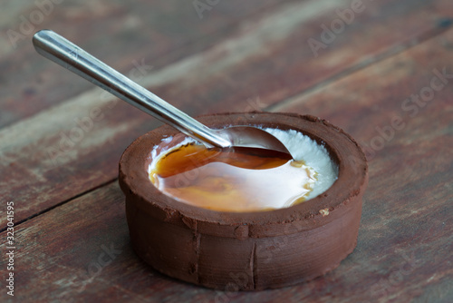 Fototapet Traditional sweet food on Sri Lanka - buffalo curdled milk with sweet palm sirup in ceramic bowl