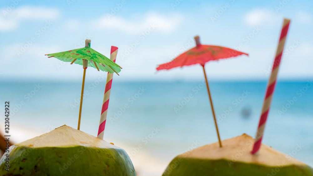Two green fresh coconuts on the tropical beach.Travel honeymoon concept