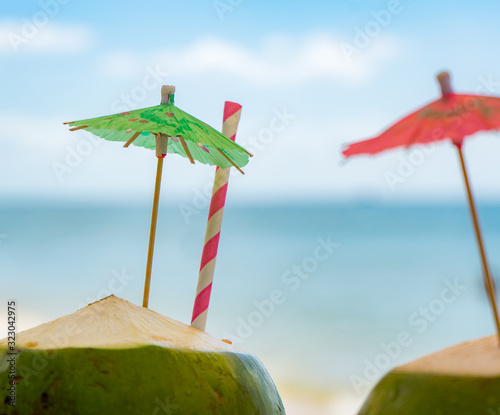 Two green fresh coconuts on the tropical beach.Travel honeymoon concept