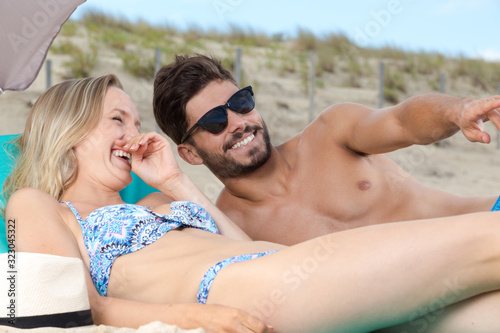 happy couple on beach laughing in sunlight