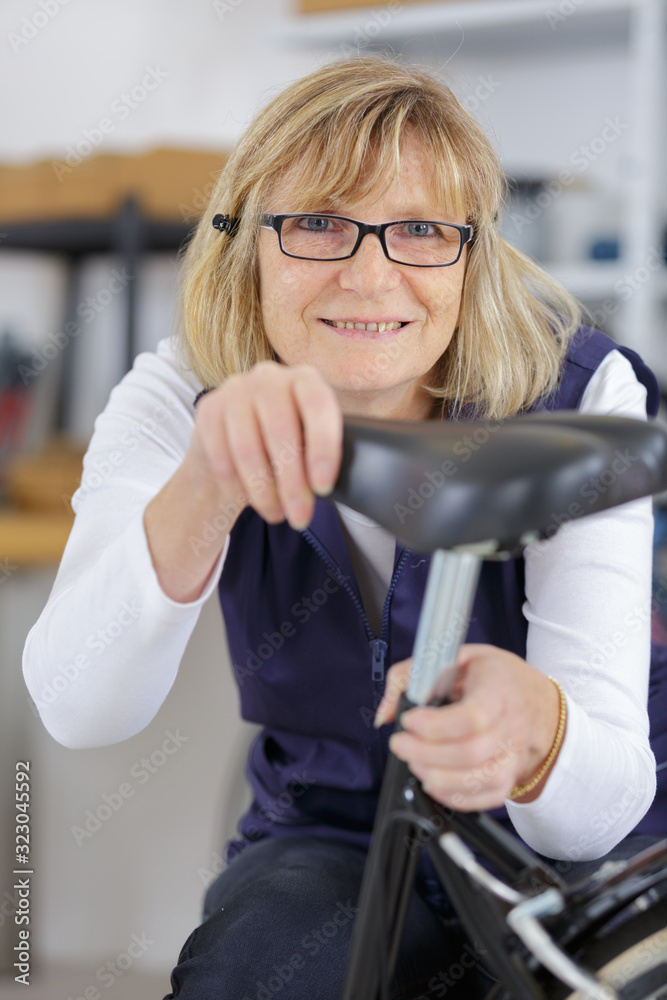 Obraz premium female mechanic repairing a bike in a workshop
