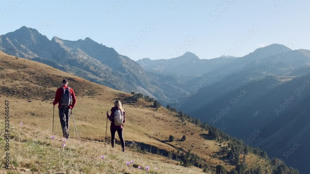 Video of two travel hikers with backpack walking while looking the landscape in the mountain. Back view. Video of two travel hikers with backpack walking while looking the landscape in the mountain. Back view.