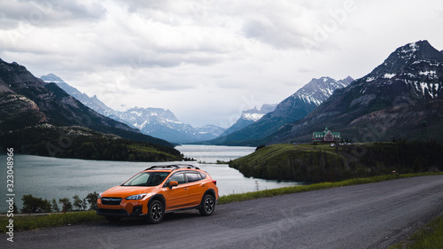 orange car parked on a hill overlooking mountains and a lake  © Chance