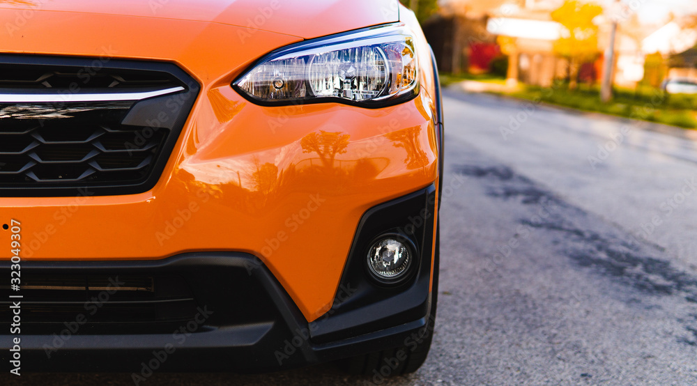 half view of a bright orange car half view of a bright orange car
