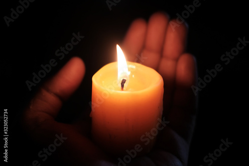 burning candle on women hand at night , close up 