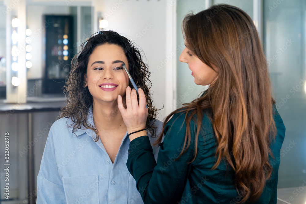 Professional make up artist doing make up to a beautiful girl