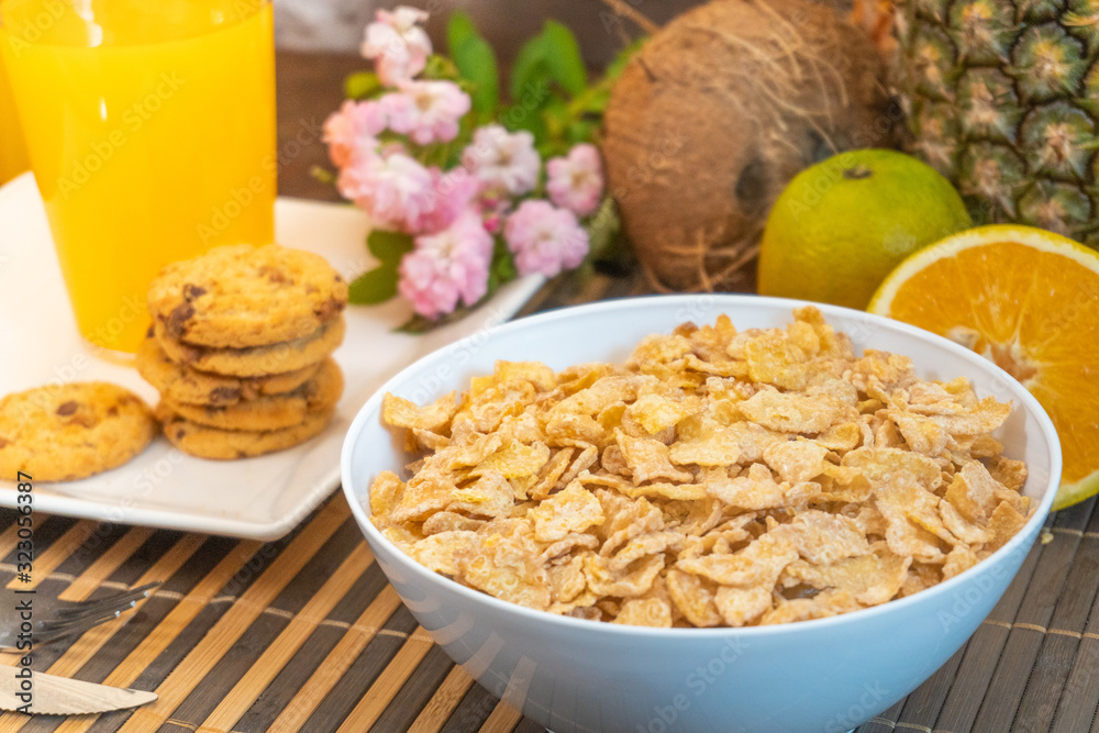 Breakfast pouring milk into corn flakes creating splash apple and orange fruit Breakfast pouring milk into corn flakes creating splash apple and orange fruit