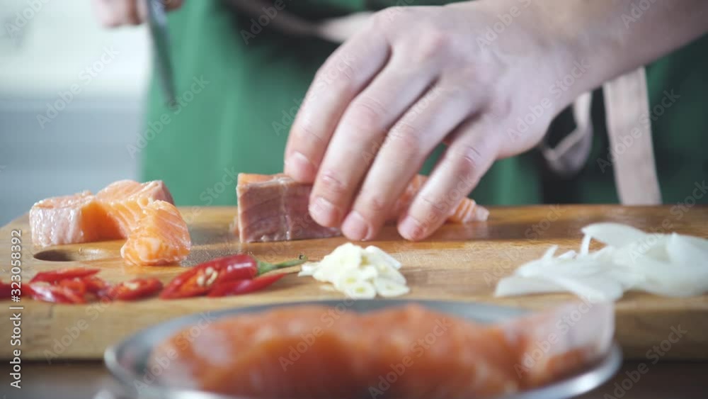 Professional chef cut fresh salmon before to cook food at kitchen restaurant. Sushi chef slices fish. Food ingredient. Cooking on cuisine. Cooked for gourmet. Prepare food to eat. Gastronomy culinary. Professional chef cut fresh salmon before to cook food at kitchen restaurant. Sushi chef slices fish. Food ingredient. Cooking on cuisine. Cooked for gourmet. Prepare food to eat. Gastronomy culinary.