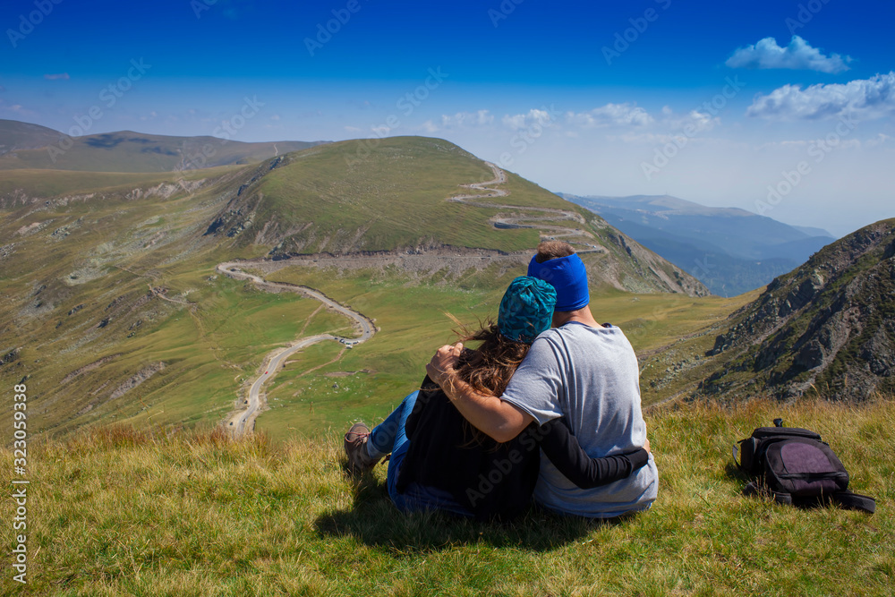couple of man and woman holding each other on mountain landscape. Parang, Romania