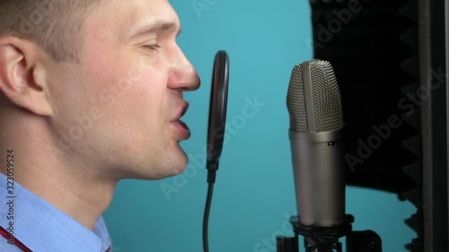 handsome young man in a tie singing into a microphone. closeup photo