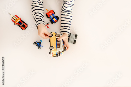 Top view of boy playing with colorful plastic bricks