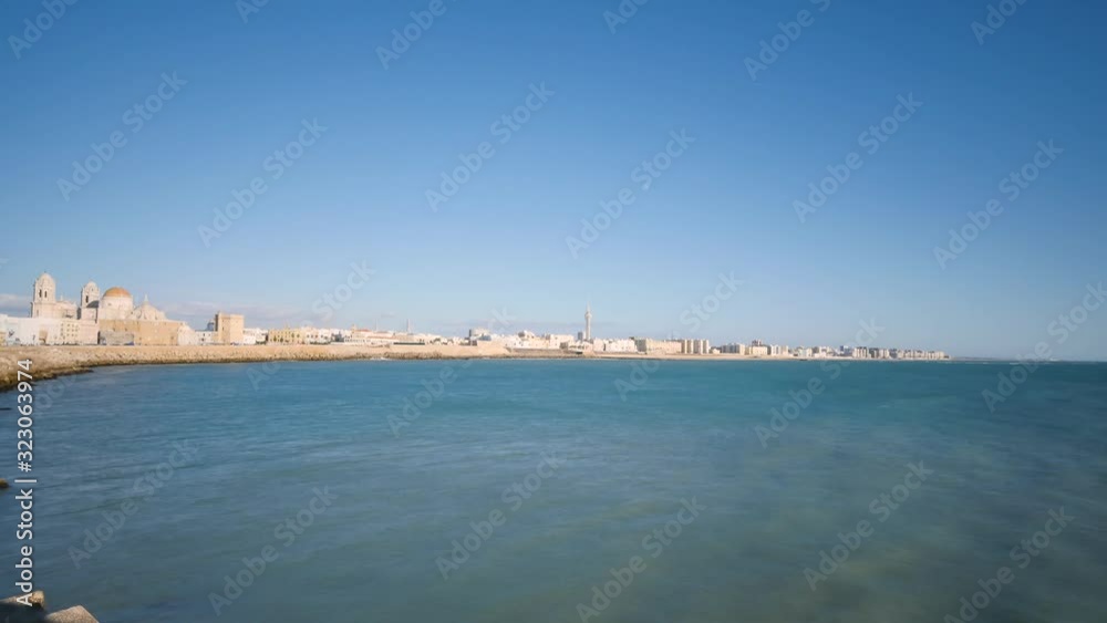 Time lapse of the coast of Cádiz in Andalusia, Spain. Blue sky, daylight. Traffic on the coast, waves on the sea. Filmed with a wide angle. Time lapse of the coast of Cádiz in Andalusia, Spain. Blue sky, daylight. Traffic on the coast, waves on the sea. Filmed with a wide angle.