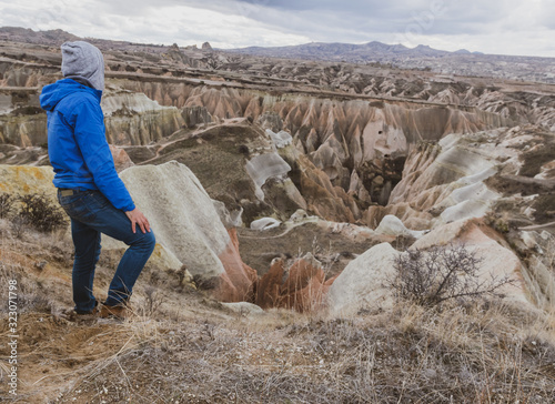 Person looks to distant dramatic moody  valley in Kapadokya. with rocky geologcal formations in the background. Exploration of interesting geologcal sites and rose valley. photo