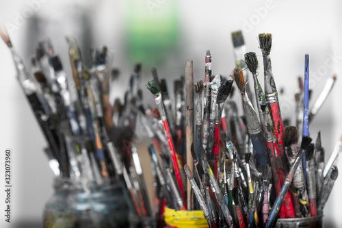 A lot dirty artist paint brushes in a bucket
