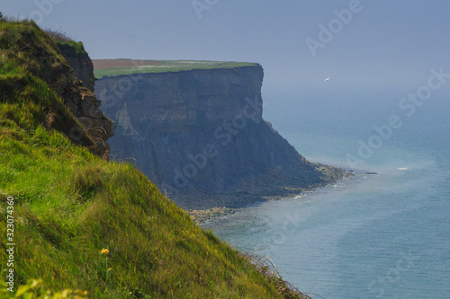 Stunning mountains and cliffs of Normandy coast on a sunny day. Arromanches-les-Bains, France
