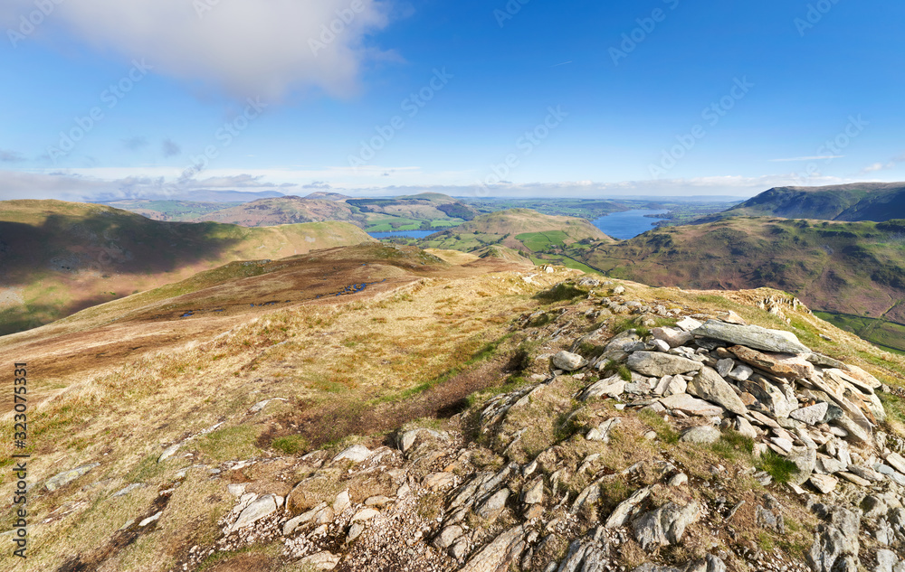 The mountain summit of Beda Head with High Dodd and Ullswater in the distance on a sunny day in the Lake District UK