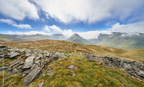 Scenic view of the mountain summits of The Knott, High Street, Thornthwaite, Gray Crag and a cloud covered Stony Cove Pike on a sunny day in the Lake District UK.