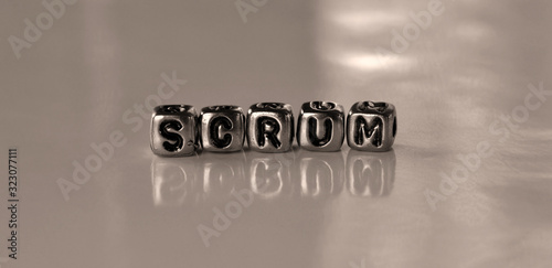 Scrum -  word from metal blocks - concept sepia tone photo on shine background