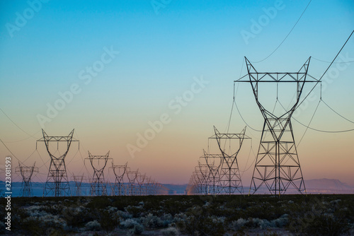USA, Nevada, Clark County, Eldorado Valley, Boulder City. The silhouette of a power transmission line vanishing into a point in the distance during sunset.