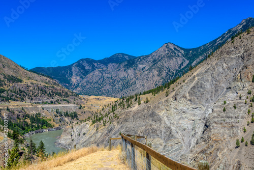 View of beautiful landscape in the Rocky Mountains with fresh blue and green mountain river water and mountain tops in the background on a sunny day with blue sky in springtime.