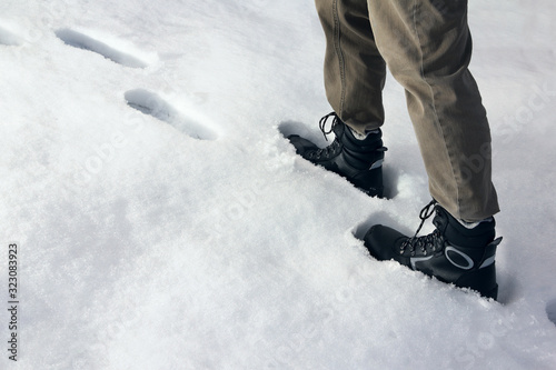 Man climbs a snowy climb, following in the footsteps of others
