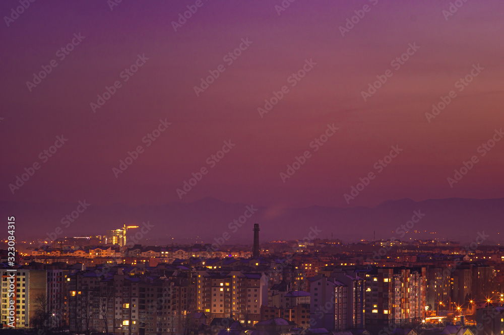 Red sunset sky over the city and mountains silhouette