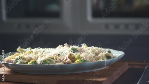 Chef sprinkles parmesan cheese spaghetti pasta on a plate in a restaurant kitchen. Food ingredient. Cooking on cuisine. Cooked for gourmet. Prepare food to eat. Gastronomy culinary. Delicious dinner.