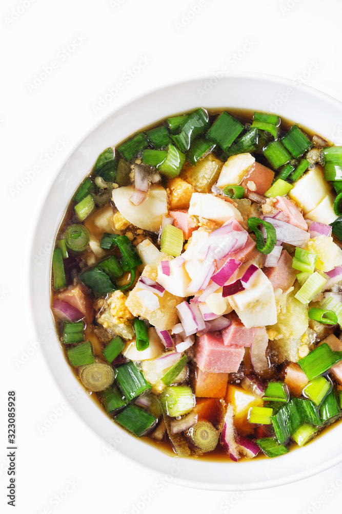 Traditional Russian summer cold soup okroshka with kvass in bowl on white background. Traditional Russian summer cold soup okroshka with kvass in bowl on white background.