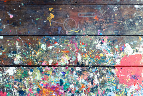 Artists workshop or studio bench covered with splattered paint built up in authentic texture on painted surface photo