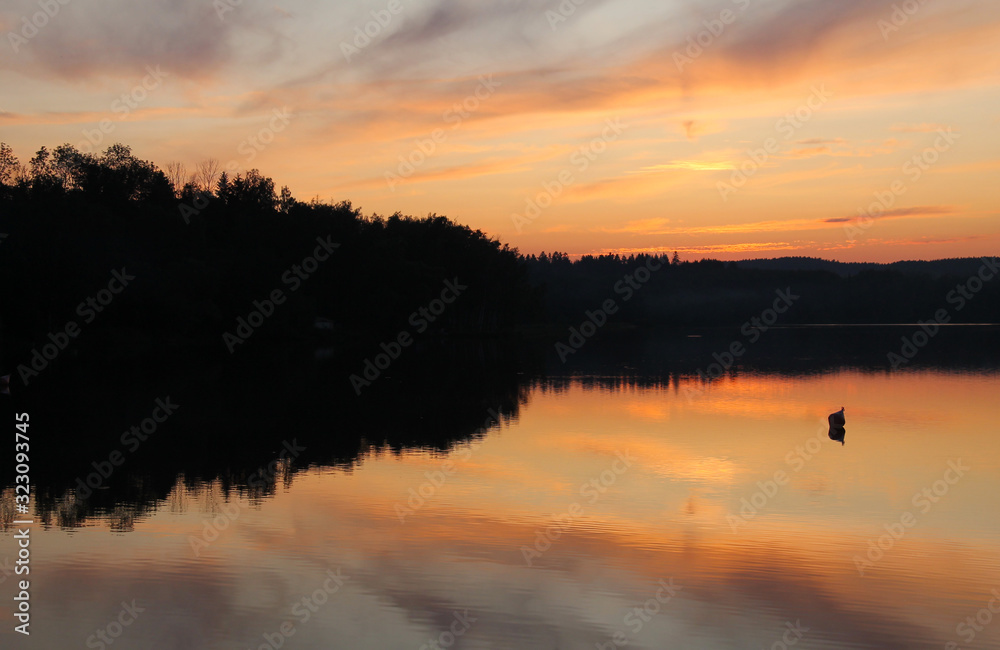 dam and colorful skies reflecting on its calm surface in Zdar nad Sazavou, Czech Republic
