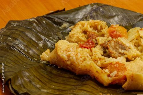 Nacatamal typical Nicaraguan food, corn, meat, butter, potatoes, onion, wrapped banana leaf photo