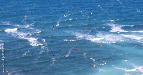 Wide view of kite surfers beach. Windsurfers riding on waves. Kite Surfing. Water-sports activity.