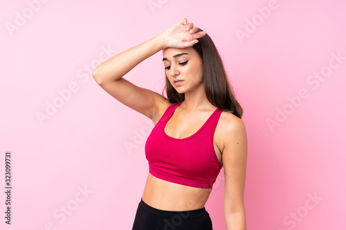 Young sport girl over isolated pink background with tired expression © luismolinero