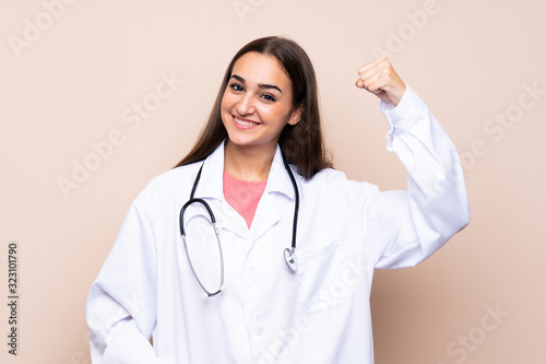Young woman over isolated background with doctor gown and making strong gesture