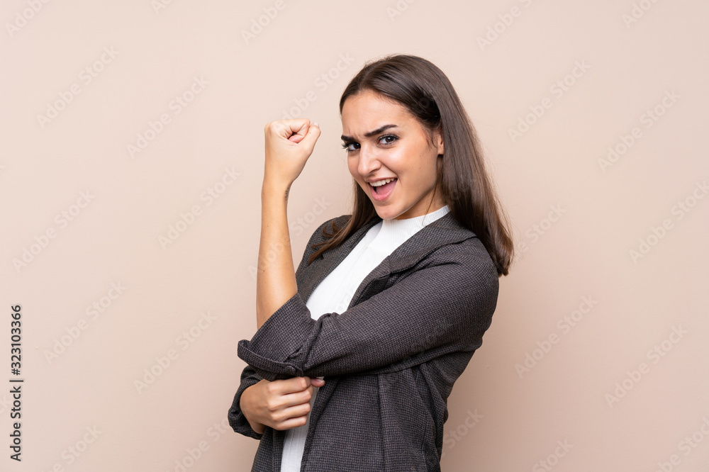 Young girl over isolated background making strong gesture Young girl over isolated background making strong gesture