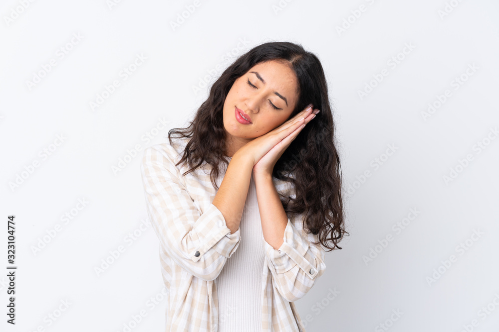 Mixed race woman over isolated white background making sleep gesture in dorable expression