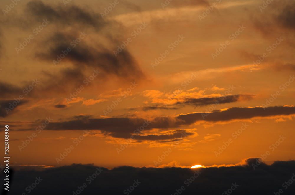 Dramatic sunset, cloudy sky of an intense orange color, in San Clemente del Tuyu